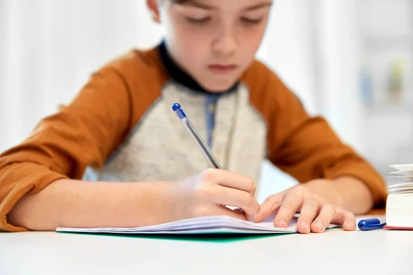 Étudiant garçon avec écriture de livre pour ordinateur portable à la maison — Photo