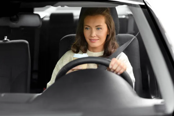 Woman or female driver with coffee driving car — Stock Photo, Image