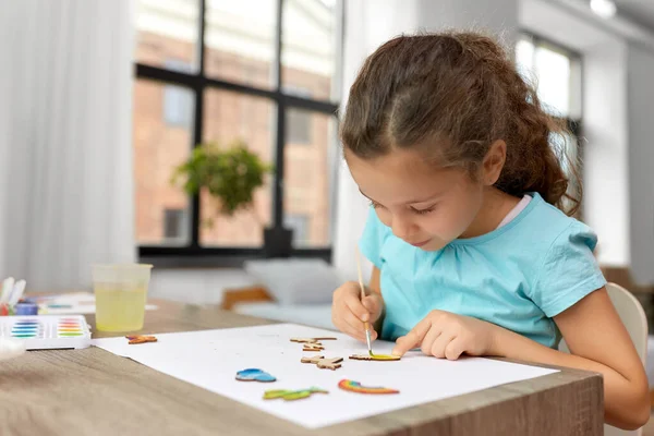 Menina pintando itens de madeira em casa — Fotografia de Stock