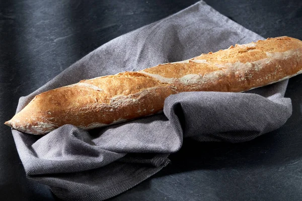 Zblízka bagetový chléb na kuchyňském ručníku — Stock fotografie