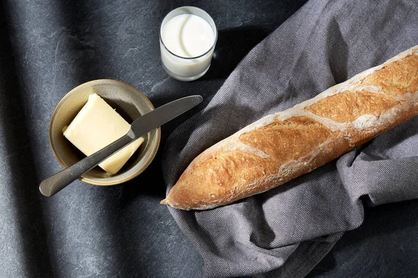Primer plano de pan, mantequilla, cuchillo y vaso de leche — Foto de Stock