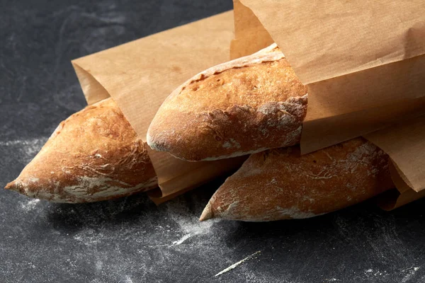 Ekmeği kağıt torbalarla masaya koy. Stok Resim
