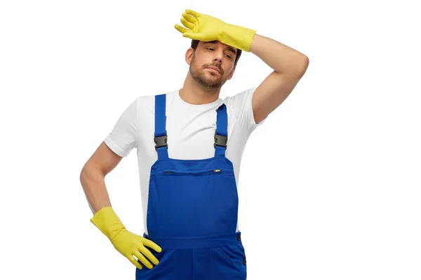 Tired male worker or cleaner in overall and gloves — Stock Photo, Image