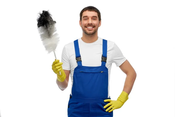 Happy male worker or cleaner with duster cleaning — Stock Photo, Image