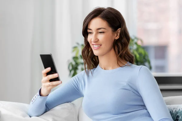 Frau mit Smartphone zu Hause — Stockfoto