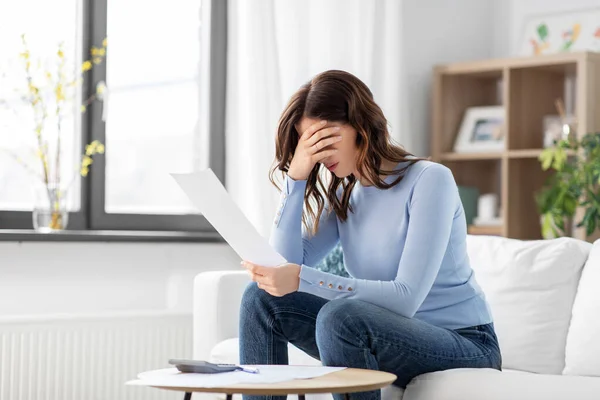 Стресс женщина с бумагами и калькулятором дома — стоковое фото