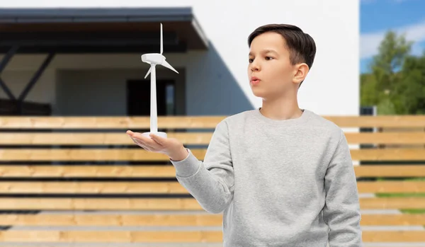 Niño con juguete aerogenerador sobre fondo de la casa — Foto de Stock