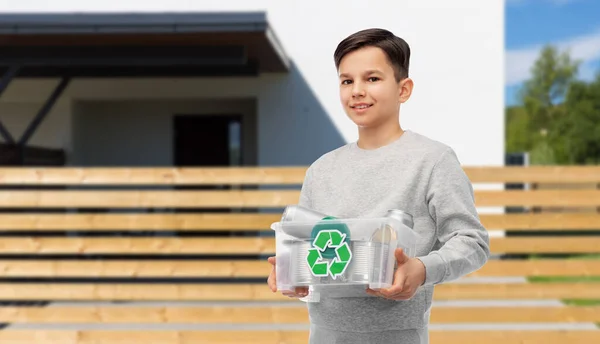 Lächelnder Junge sortiert Metallmüll über Haus — Stockfoto