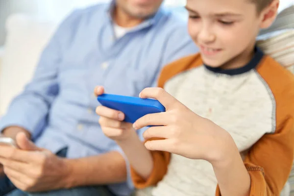 Vater und Sohn mit Smartphones zu Hause — Stockfoto
