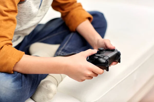 Anak laki-laki dengan gamepad bermain video game di rumah — Stok Foto