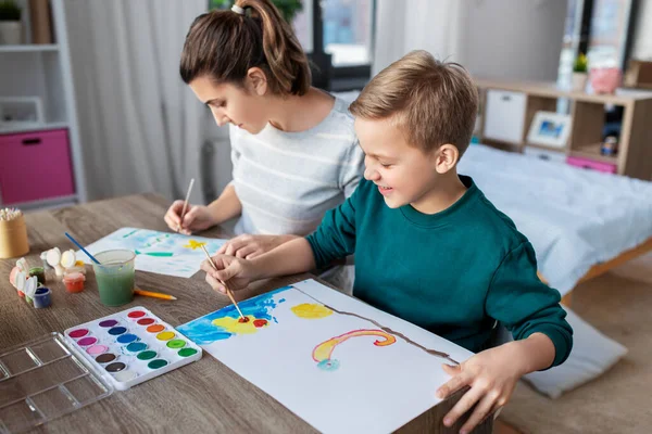 母亲和儿子在家里画彩绘 — 图库照片