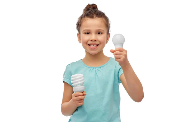 Smiling girl comparing different light bulbs — Stock Photo, Image