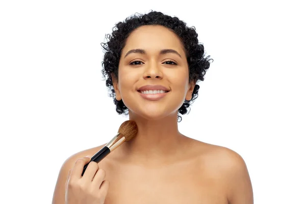 Mulher com maquiagem escova aplicando shimmer para a pele — Fotografia de Stock