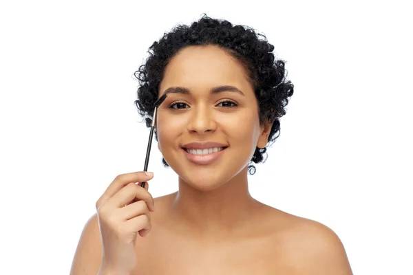 Lächelnde Afroamerikanerin mit Mascara-Bürste — Stockfoto