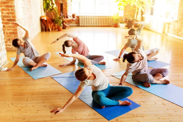 Grupo de pessoas fazendo exercícios de ioga no estúdio — Fotografia de Stock