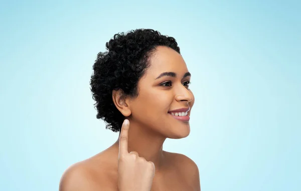 Lächelnde Afroamerikanerin zeigt ihr Ohr — Stockfoto