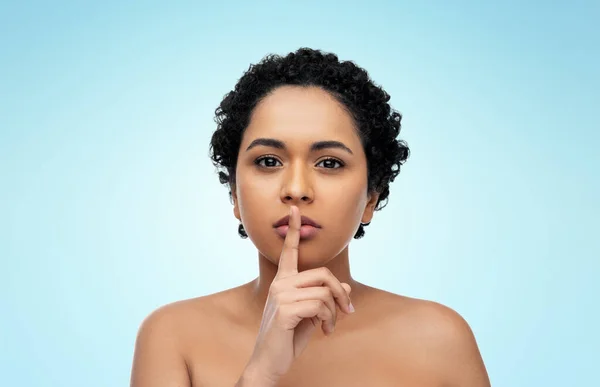 Joven afroamericana mujer con dedo en los labios — Foto de Stock