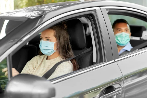 Conductor femenino en el coche de conducción de máscara con pasajero — Foto de Stock