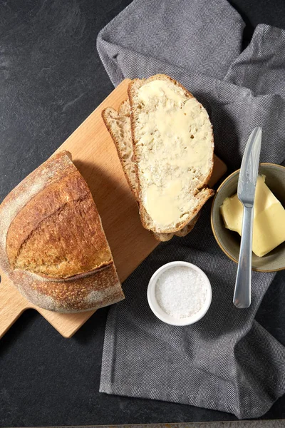 Primer plano de pan, mantequilla, cuchillo y sal en la toalla — Foto de Stock
