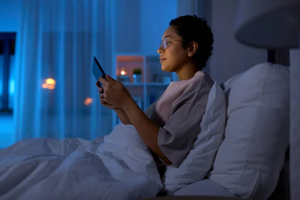 Mujer con tableta pc en la cama en casa por la noche —  Fotos de Stock