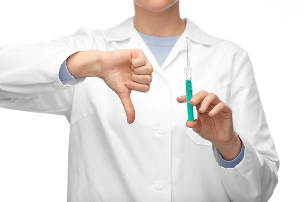 Zblízka lékař s injekční stříkačkou ukazuje palce dolů — Stock fotografie