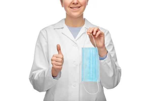 Женщина-врач в медицинской маске показывает большие пальцы вверх — стоковое фото