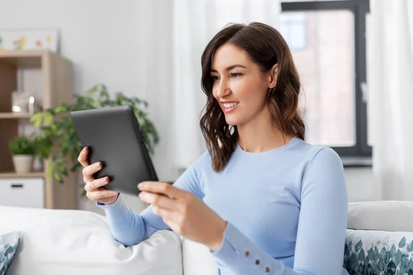 Glücklich lächelnde junge Frau mit Tablet-PC zu Hause — Stockfoto