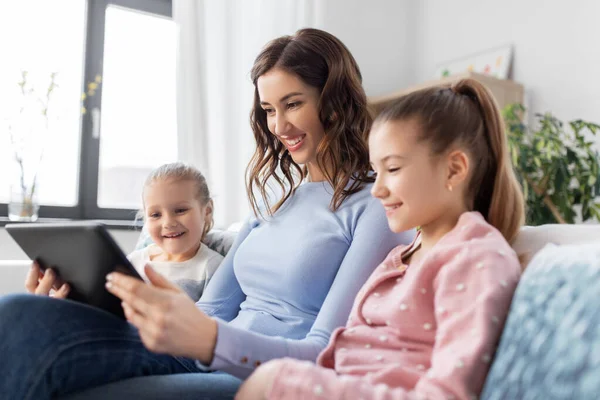 Feliz madre e hijas con la tableta PC en casa —  Fotos de Stock