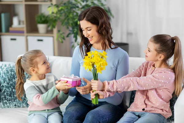 Дочери дарят цветы и подарок счастливой матери — стоковое фото