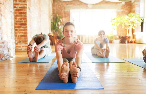 Groep van mensen doen yoga vooruit buigen in de studio — Stockfoto