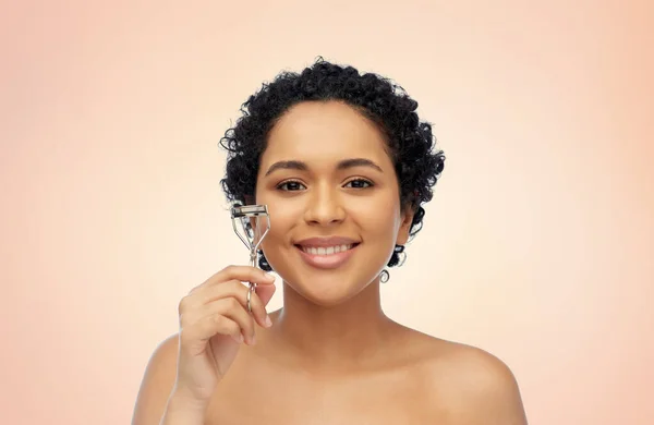 Lächelnde Afroamerikanerin mit Wimpernzange — Stockfoto