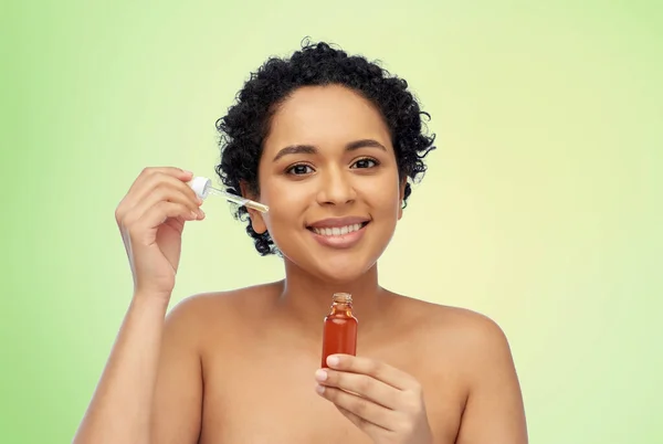 Glücklich afrikanisch-amerikanische Frau mit einer Flasche Serum — Stockfoto