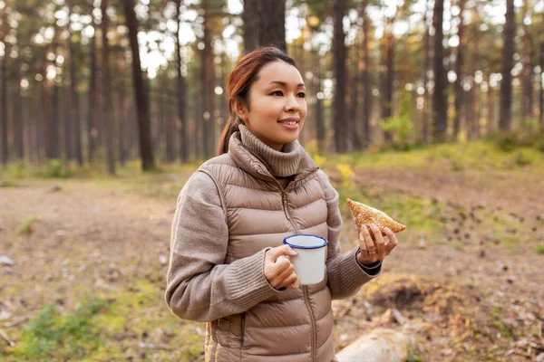 キノコを持つ女性はお茶を飲んで森の中で食べる — ストック写真
