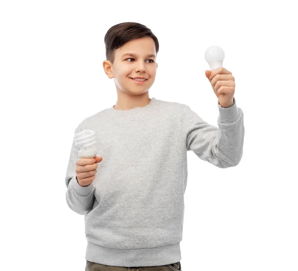 Sorrindo menino comparando lâmpadas diferentes — Fotografia de Stock