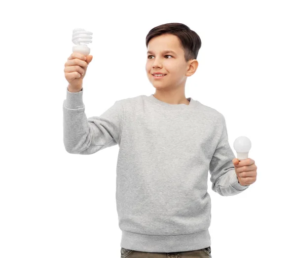 Sorrindo menino comparando lâmpadas diferentes — Fotografia de Stock