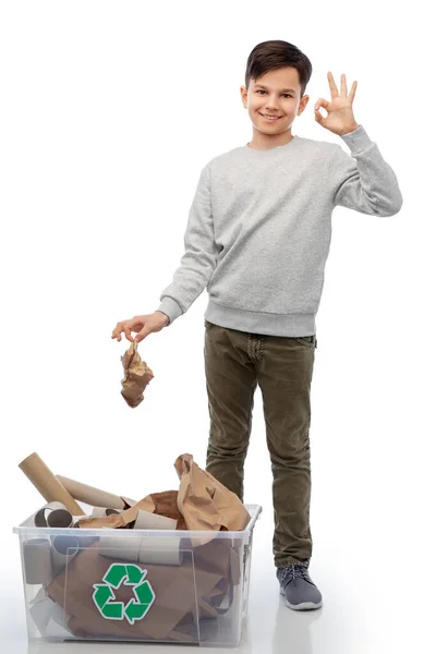 Lächelnder Junge, der Papiermüll sortiert, zeigt Ok-Zeichen — Stockfoto