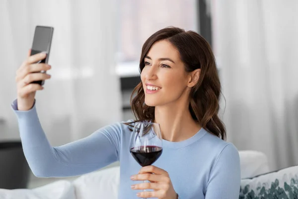 Žena s chytrým telefonem a víno přičemž selfie — Stock fotografie