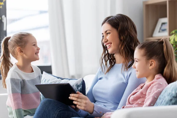Mãe feliz e filhas com tablet pc em casa — Fotografia de Stock