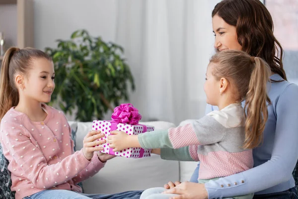 Chica dando regalo a la hermana menor en casa —  Fotos de Stock