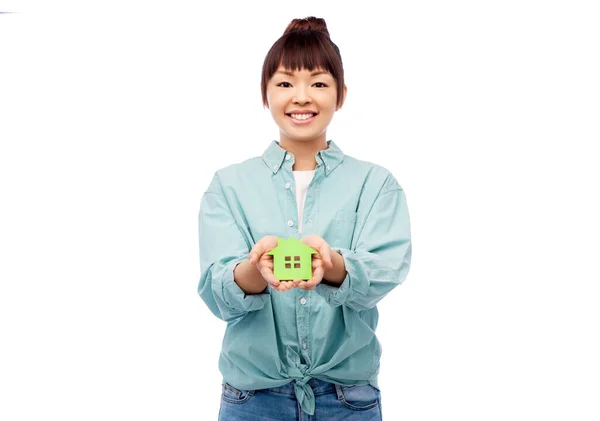 Gülümseyen Asyalı kadın yeşil evi tutuyor. — Stok fotoğraf