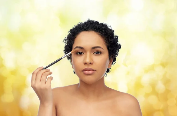 Mulher americana africana com maquiagem escova — Fotografia de Stock