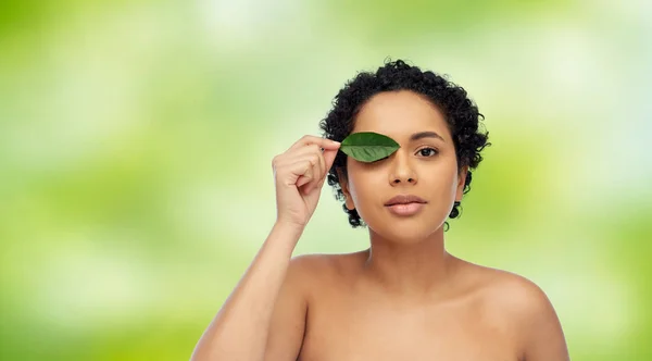 Portrait of african american woman with green leaf — Stock Photo, Image