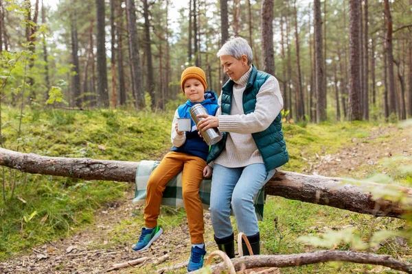 Nonna con nipote che beve tè nella foresta — Foto Stock