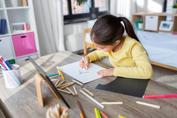 Evde boyalı kalemlerle resim çizen küçük kız. — Stok fotoğraf