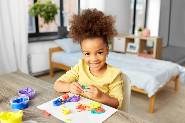 Klein meisje met modelleren klei spelen thuis — Stockfoto