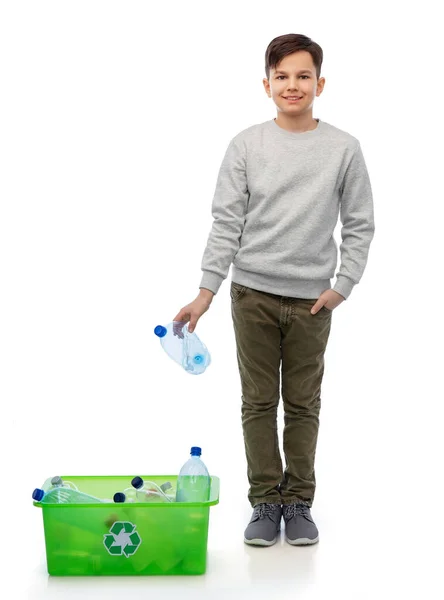 Улыбающийся мальчик сортирует пластиковые отходы — стоковое фото
