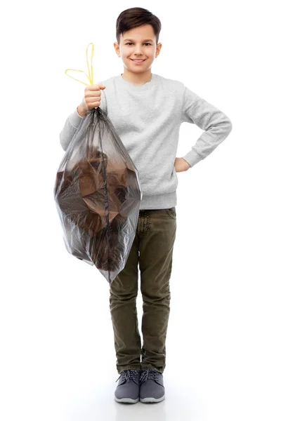 Улыбающийся мальчик с бумажным мусором в пластиковом пакете — стоковое фото