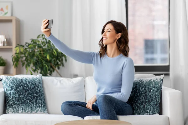 Boldog nő smartphone csinál selfie otthon — Stock Fotó
