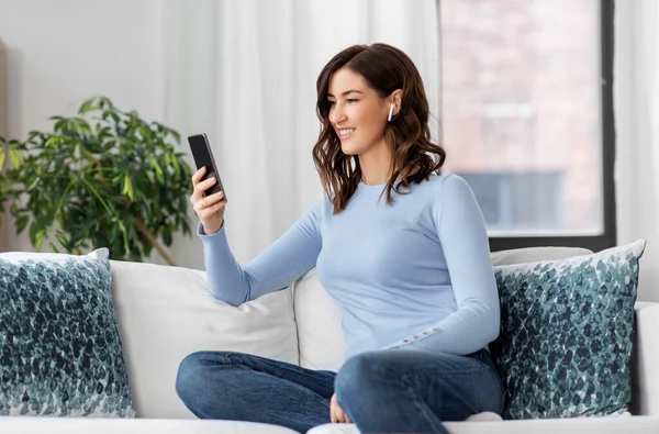 Frau mit Kopfhörer und Smartphone zu Hause — Stockfoto