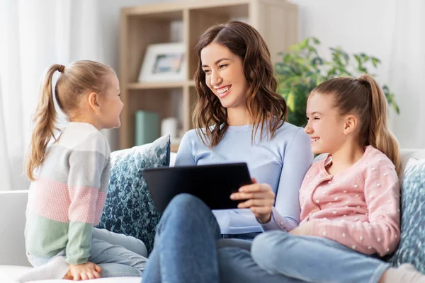 Gelukkig moeder en dochters met tablet pc thuis — Stockfoto